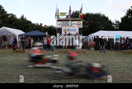 Team members in the pit lane watch the action in the British Lawn Mower Racing Association 12 hour endurance race at Five Oaks near to Billingshurst in West Sussex. Stock Photo