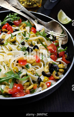 Pasta with crushed olives and cherry tomatoes, arugula. Stock Photo