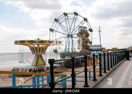 Seaside, Carnival, Fair, Amusement Rides on the Beach, Ferris Wheel, Slide, Swing Ride, Empty, Derelict, Railings, England, Cleethorpes, Sand, Pathway Stock Photo