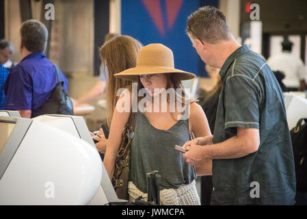 Airline passengers at Atlanta International Airport using Delta Air Line's Self Check In kiosks for boarding passes in Atlanta, Georgia, USA. Stock Photo