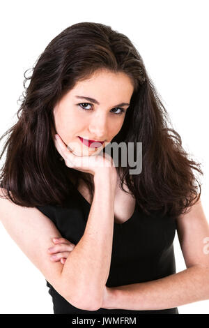 An attractive young subtly smiling brunette caucasian teen girl in a black dress Stock Photo