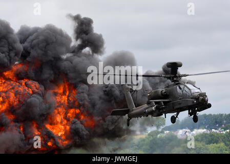 British Army Agusta Westland AH-64 Apache AH1 attack helicopter with exploding pyrotechnics at RIAT airshow Stock Photo