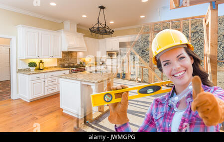 Female Construction Worker In Front of House Framing Gradating to Finished Kitchen Photo. Stock Photo