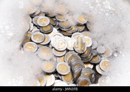 conceptual image of money laundering, mexican pesos coins with soap foam Stock Photo
