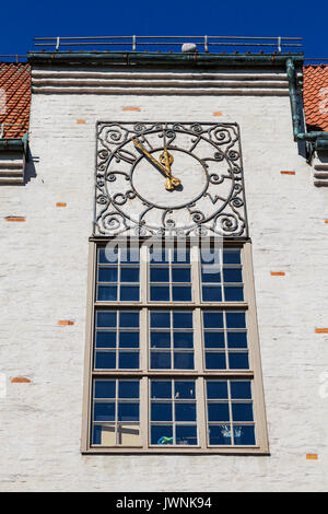 Ancient clock with golden arrows on old City hall wall. Hedemora, Sweden. Stock Photo