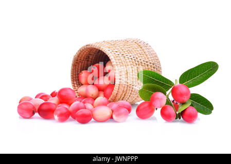 karanda or carunda tropical fruit in wooden basket with green leaves isolated on white background Stock Photo