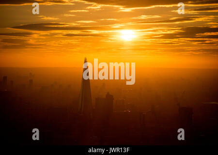 The sun rises over the Shard in central London as warmer weather returns to the south of England. Stock Photo