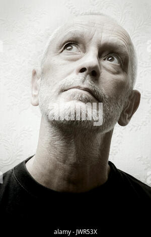 Black and white portrait of an inquiring caucasian adult gentle man with eyes looking up Stock Photo