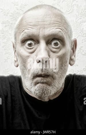 Portrait of a surprised and angry caucasian man with a penetrating gaze and astonishment in the eyes Stock Photo