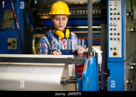 Portrait of beautiful woman checking machines  in modern factory working in quality control Stock Photo