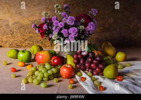 Still life with Fruits were placed together with a vase of flowers beautifully. Stock Photo