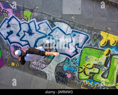A skateboarder performs a trick, shot from above as an unusual angle Stock Photo