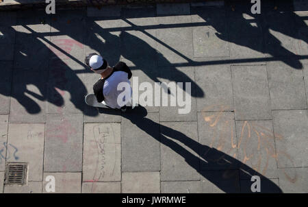 Long shadows of a skateboarder, taken from above as he commutes home Stock Photo