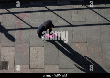 Long shadows of a skateboarder, taken from above as he commutes home Stock Photo