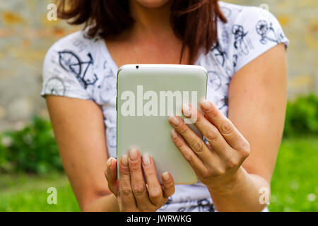 Black tablet in women hands and blurred background Stock Photo