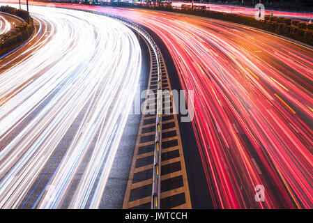 Cars light trails on a curved highway road at night in Chengdu city Stock Photo