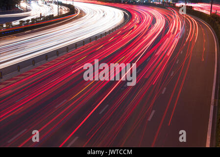 Cars light trails on a curved highway road at night in Chengdu city Stock Photo