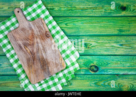 Cutting board over green checkered tablecloth, top view Stock Photo