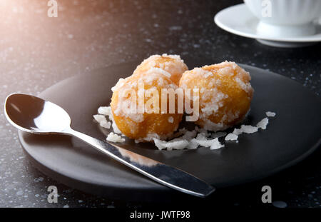 Thai dessert Khai hong it's mean swan egg made from rice flour green beans and sugar cover set on black plate in tea break style. Stock Photo