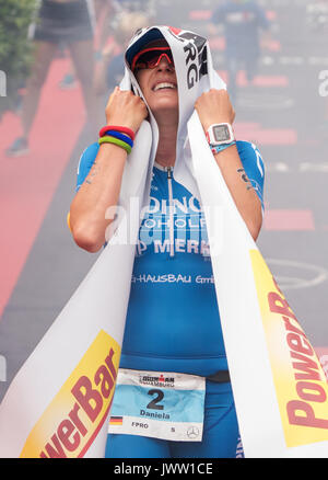 Hamburg, Germany. 13th Aug, 2017. German athlete Daniela Saemmler crosses the Ironman finish line in first place in Hamburg, Germany, 13 August 2017. Around 2500 athletes swam 3.8 kilometres in the Alster, cycled 180 kilometres through Lower Saxony and Hamburg and ran a 42 kilometre marathon round the Alster lakes. Saemmler finished first in the women's event. Photo: Daniel Bockwoldt/dpa/Alamy Live News Stock Photo