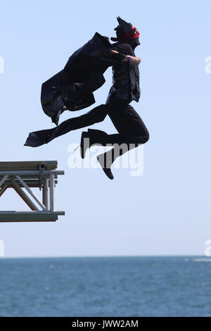 Bognor Regis, UK. 13th August, 2017. A participant in costume tries to fly as far as possible in a hand made flying machine off the end of Bognor Resgis pier during the International Bognor Birdman competition at Bognor Regis, West Sussex, UK Sunday August 13, 2017. A hot and sunny afternoon with a gentle breeze provided the perfect weather conditions for the annual event. Photograph : Credit: Luke MacGregor/Alamy Live News Stock Photo