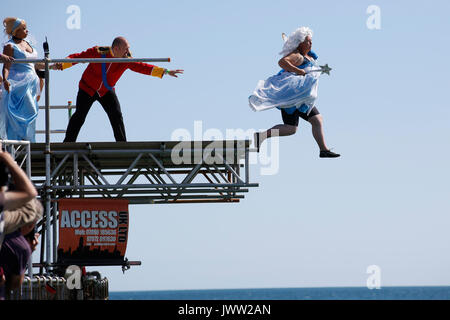 Bognor Regis, UK. 13th August, 2017. A participant in costume tries to fly as far as possible in a hand made flying machine off the end of Bognor Resgis pier during the International Bognor Birdman competition at Bognor Regis, West Sussex, UK Sunday August 13, 2017. A hot and sunny afternoon with a gentle breeze provided the perfect weather conditions for the annual event. Photograph : Credit: Luke MacGregor/Alamy Live News Stock Photo