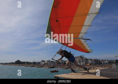 Bognor Regis, UK. 13th August, 2017. A participant in costume tries to fly as far as possible in a hangglider off the end of Bognor Resgis pier during the International Bognor Birdman competition at Bognor Regis, West Sussex, UK Sunday August 13, 2017. A hot and sunny afternoon with a gentle breeze provided the perfect weather conditions for the annual event. Photograph : Credit: Luke MacGregor/Alamy Live News Stock Photo