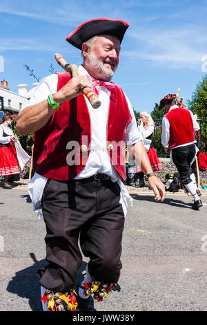 Traditional English folk dancers, Victory Morris group, dancing during Broadstairs Folk Week. Wearing crimson waistcoats and pirate hats, and dancing while holding wooden poles. Stock Photo