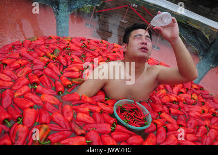 Changsha, Changsha, China. 12th Aug, 2017. Changsha, CHINA-August 12 2017: (EDITORIAL USE ONLY. CHINA OUT) .Tourists attend a chilli pepper eating contest at a scenic area in Changsha, central China's Hunan Province, August 12th, 2017. Credit: SIPA Asia/ZUMA Wire/Alamy Live News Stock Photo