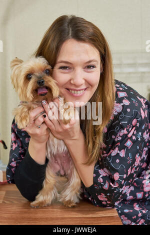 Smiling woman and yorkshire terrier. Happy female with a dog. Benefits of having a pet. Stock Photo
