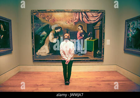 A visitor stands in front of a large classical painting by one of the great masters in a gallery in the Philladelphia Museum of Art, Philladelphia, Pe Stock Photo