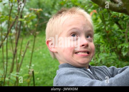 Boy with down syndrome showing his strength. Stock Photo