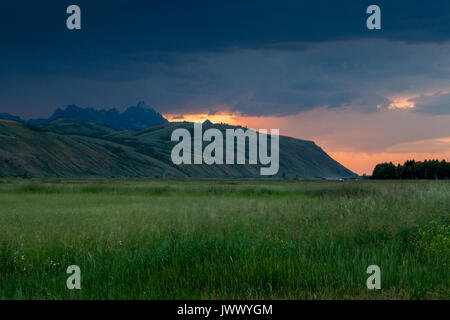 A stormy sunset creating a colorful sky over a ranch near Jackson, Wyoming. Stock Photo
