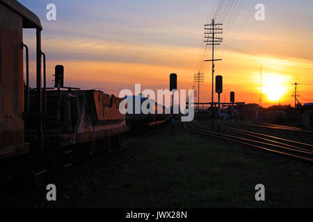 Cargo train parking near Train Station at sunset and twilight sky Stock Photo