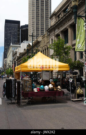Market Stall Selling Shirts, Clothes, Sunglasses and Sun Hats on 8 Avenue and Stephen Avenue SW in Downtown Calgary Alberta Canada Stock Photo