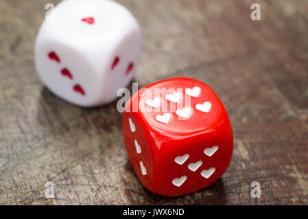 two dices with hearts on wooden table Stock Photo