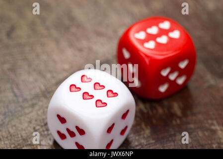 two dices with hearts on wooden table Stock Photo