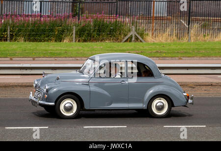 A family enjoying a day out driving in their vintage Morris 1000 car along the Kingsway West dual carriageway in Dundee, UK Stock Photo