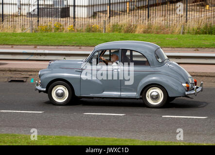 A family enjoying a day out driving in their vintage Morris 1000 car along the Kingsway West dual carriageway in Dundee, UK Stock Photo