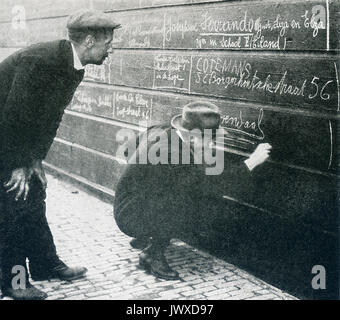 This photo taken in Europe early in World War I has as its caption: An Impromptu Registration. Refugees from Antwerp writing their names and address on a fence to let  their friends known their whereabouts. Stock Photo