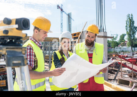architect sharing ideas about plan of building project on construction site Stock Photo