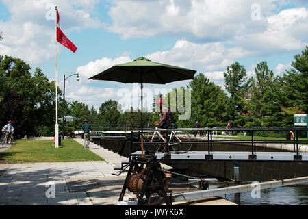 Cyclist crossing over the top gate at the lock at Carleton University, Rideau Canal, Ottawa, Ontario, Canada. Stock Photo