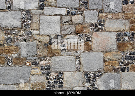 Wall composed of diverse square  blocks of granite, chert, flint, and other rocks, gray, brown, rust and black: use for a background, screen saver Stock Photo