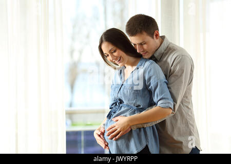 New parents enjoying pregnancy touching belly at home Stock Photo