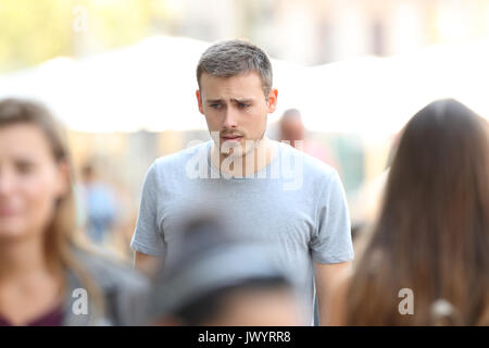 Front view portrait of a sad boy walking on the street Stock Photo