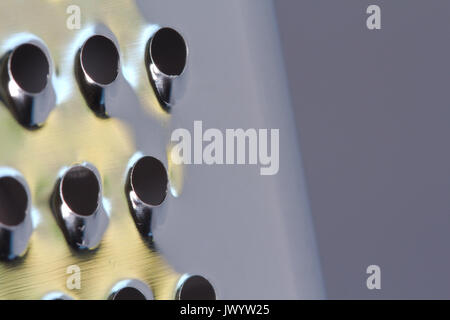 A closeup of an everyday common kitchen utensil, the cheese grater. It's also used for grating vegetables for cooking and chocolate for baking. Stock Photo
