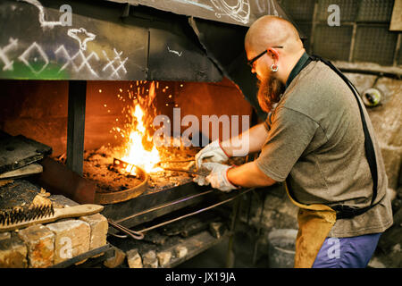 Blacksmith with beard working in his workshop Stock Photo