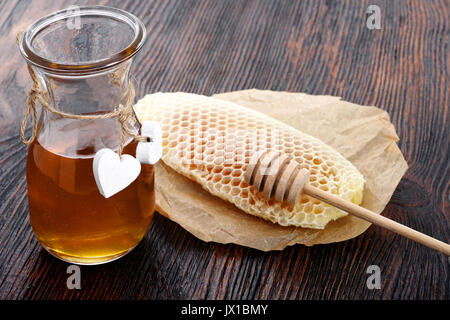 Jars of honey bee honeycomb and bee pollen on wooden table with wax honeycomb Stock Photo