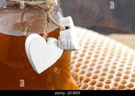 Jars of honey bee honeycomb and bee pollen on wooden table with wax honeycomb Stock Photo
