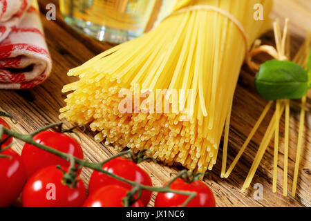 Bundle of dried spaghetti and tomatoes Stock Photo